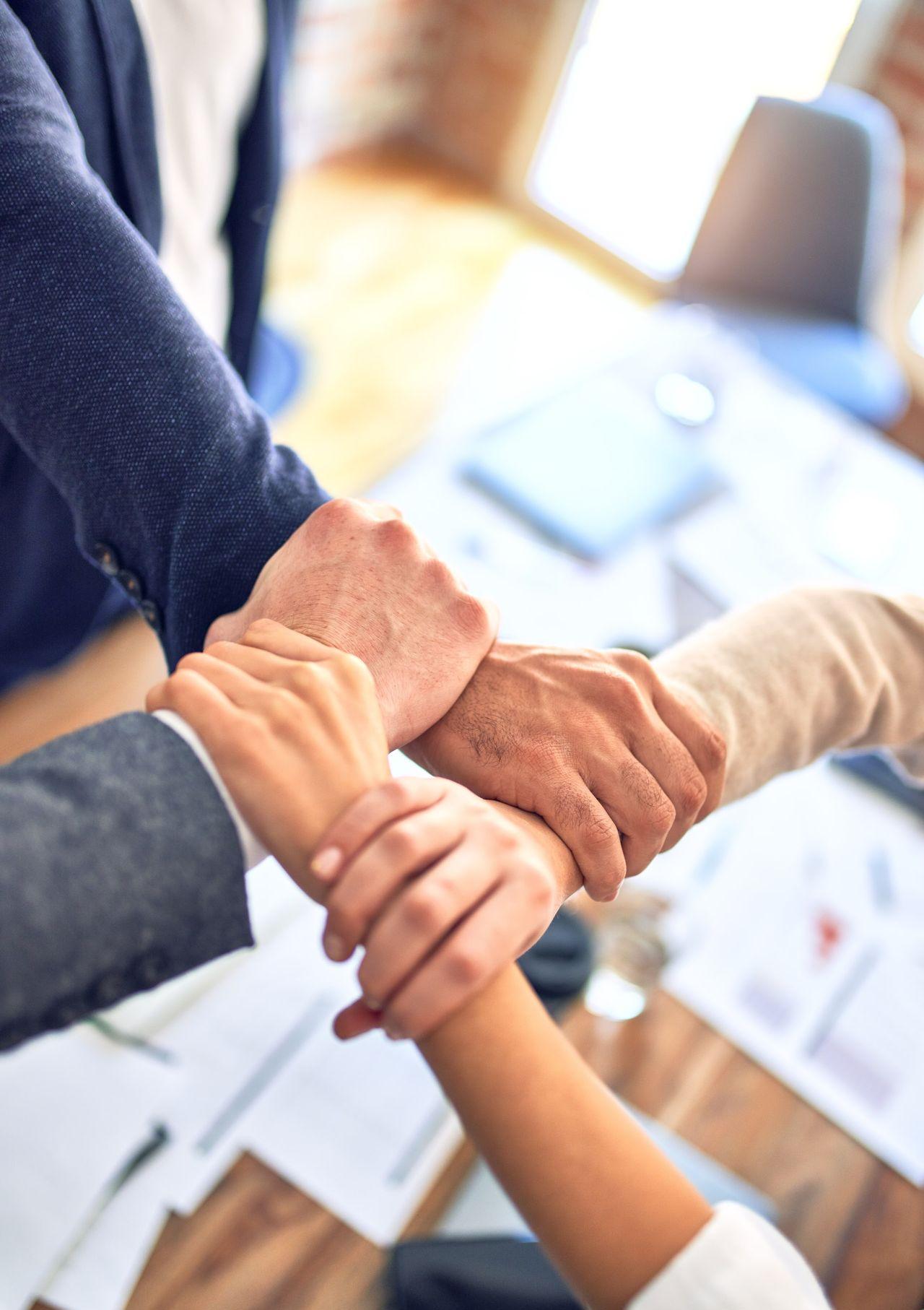 person in black long sleeve shirt holding persons hand