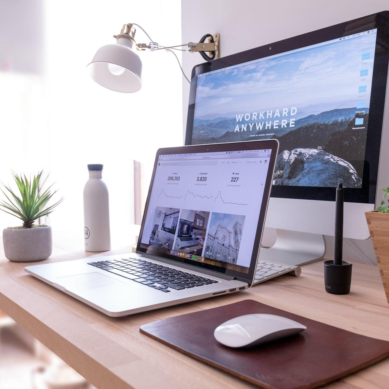 MacBook Pro on table beside white iMac and Magic Mouse